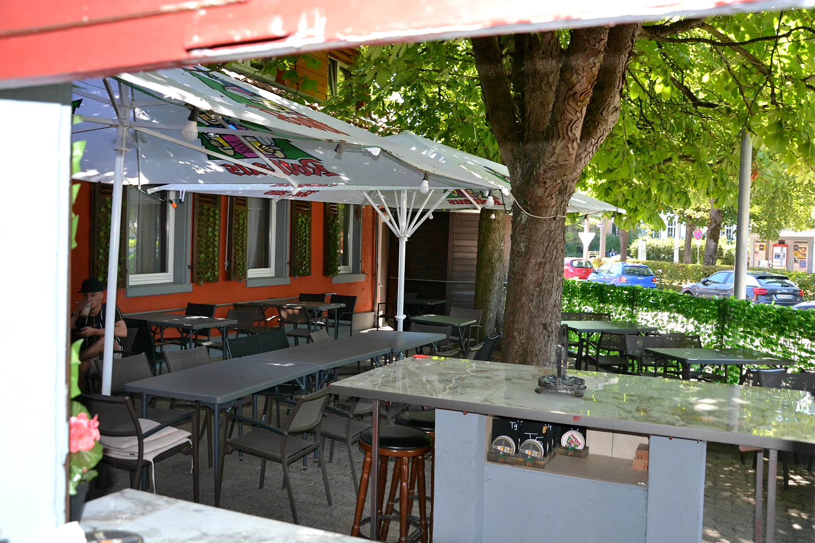 Biergarten mit Rothaus-Schirmen unter Kastanienbäumen